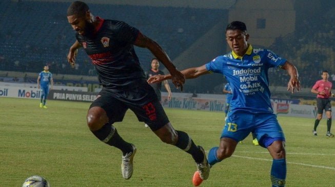 Winger Persib Bandung, Febri Hariyadi (kanan) berebut bola dengan pesepakbola Kalteng Putra, Rafael Bonfim . (Ist)