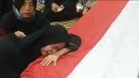 Istri almarhum Bripka RE menangis di peti jenazah suaminya di Depok. (Suara.com/Supriyadi)
