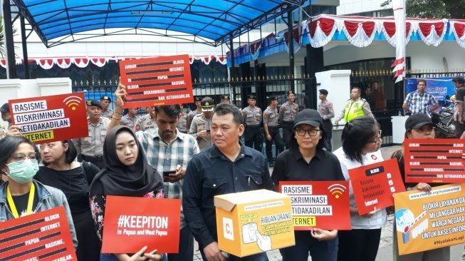 Sejumlah orang berdemonstrasi di depan Kantor Kominfo di Jakarta menolak blokir internet di Papua, Jumat (23/8/2019). [Suara.com/Novian Ardiansyah]