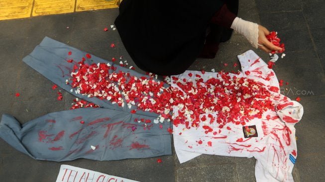 Massa aksi yang tergabung dalam Solidaritas Emak-Emak Indonesia melakukan tabur bunga di depan Polda Metro Jaya, Jakarta, Minggu (13/10). [Suara.com/Arya Manggala]