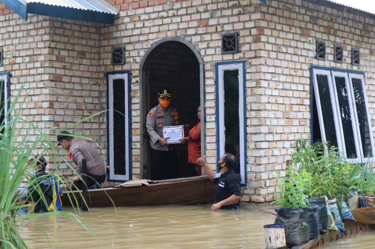 Kapolres Muaro Jambi, AKBP Ardiyanto saat bagi sembako ke warga terdampak banjir. Foto: Uda/Jambiseru.com