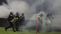 Aparat keamanan menembakkan gas air mata untuk menghalau suporter yang masuk lapangan usai pertandingan sepak bola BRI Liga 1 antara Arema melawan Persebaya di Stadion Kanjuruhan. (Suara.com)