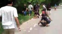 Warga membantu memutik uang korban perampokan yang berserakan di Jalan.