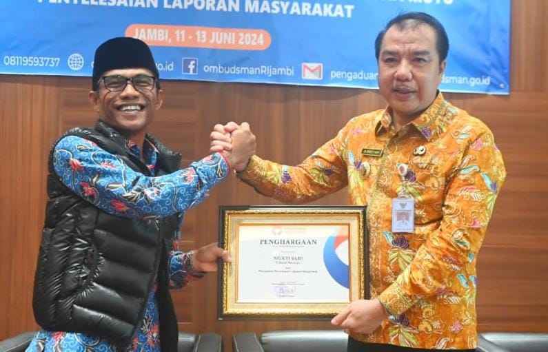 Pj Bupati Merangin H Mukti saat menerima penghargaan dari Ombudsman RI Perwakilan Provinsi Jambi, Saiful Roswandi.