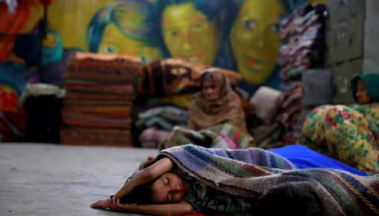seorang anak tidur di tempat penampungan pemerintah bagi para tunawisma untuk menghindari kedinginan di delhi, india