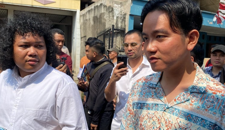 gibran blusukan di pondok aren, tangsel. dia membagikan buku dan susu ke anak anak.
