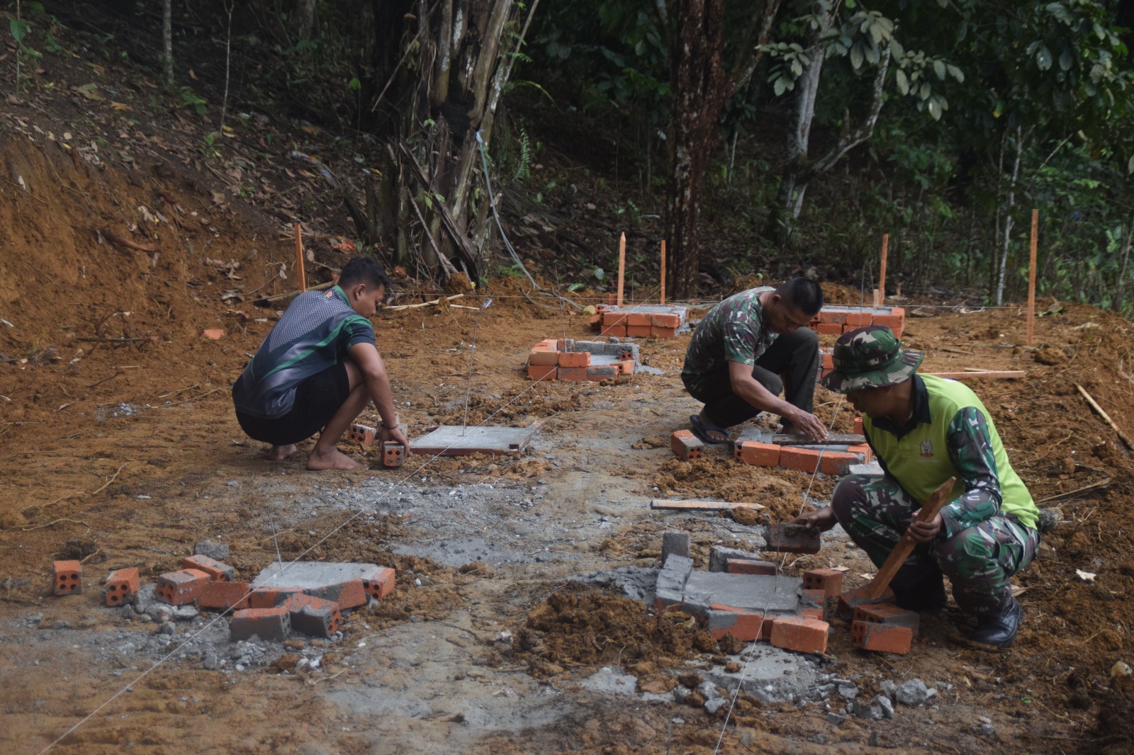 Anggota Satgas TMMD 122 Kodim 0420/Sarko Buka Cor Tiang Pondasi Kandang Kambing. Sabtu (12/10/2024).