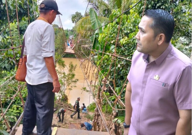 Guru SDN 117 di Desa Limbur, Kabupaten Merangin, Provinsi Jambi viral melintasi jembatan yang rusak.