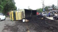 truk batubara terguling di tengah jalan